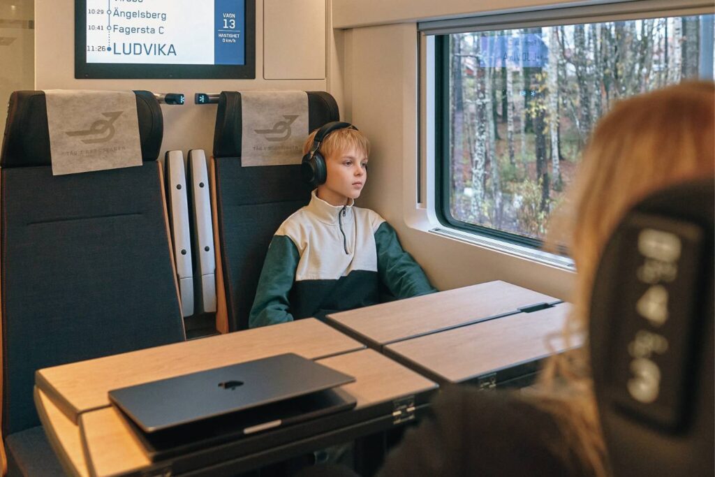 Mindfulness på tåget, ungdom som sitter och tittar ut och har hörurar på sig.
