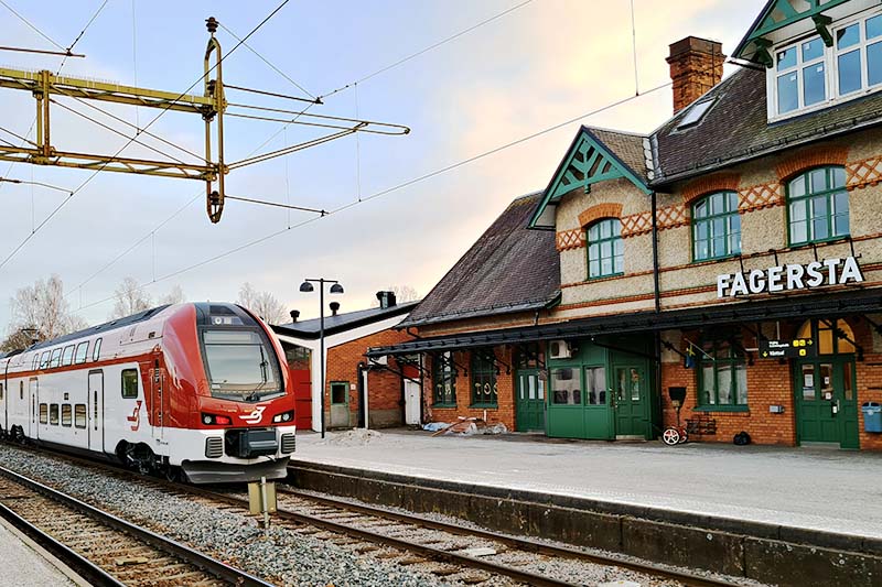 Tåg vid Fagersta C. Tåg I Bergslagens dubbeldäckare vid stationen Fagersta C och det teglade stationshuset.